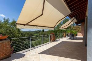 a patio with a large umbrella on a building at Sunset Serenity Villa in Padenghe sul Garda