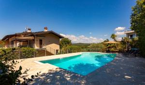 a swimming pool in front of a house at Sunset Serenity Villa in Padenghe sul Garda