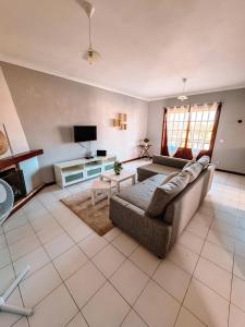 a living room with a couch and a tv at Titi's House in Gulpilhares