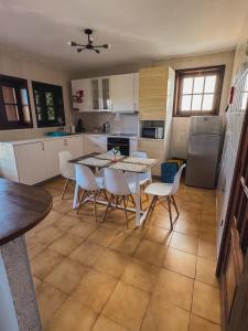 a kitchen with a table and chairs in it at Titi's House in Gulpilhares