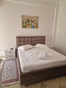 a bedroom with a large bed with white sheets at Villa Noah in Berat