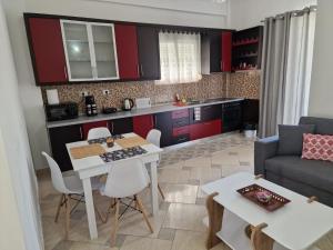 a kitchen and living room with red cabinets at Villa Noah in Berat