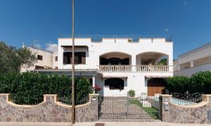 a white house with a balcony and a fence at Villa Nicole Vista Mare in Andrano +28 photos