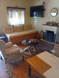a living room with a couch and a fireplace at Δυό Πηγές in Mouresi