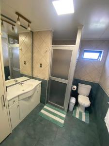 a bathroom with a toilet and a sink at The White House Hostel in Puerto Natales