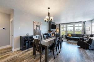 a dining room and living room with a table and chairs at Rivergrass by Property Valet in Blue Mountains