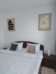 a bedroom with a bed with two pictures on the wall at Adrian Home City in Ploieşti
