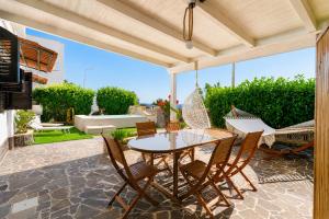 a patio with a table and chairs and a hammock at Villa Nicole Vista Mare in Andrano