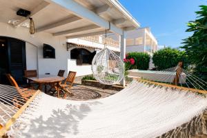 a hammock on the patio of a house at Villa Nicole Vista Mare in Andrano