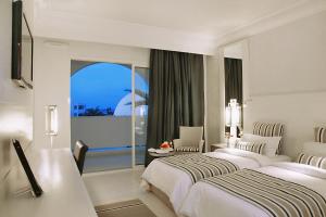Djerba Plaza Thalasso & Spa في ميدون: غرفة فندقية بسريرين ونافذة