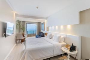 a bedroom with a large white bed with a view of the ocean at HY Apartaments & Hotels-Boa Viagem in Recife