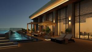 a building with a swimming pool with chairs and tables at Novotel Bhubaneswar Janpath in Bhubaneshwar