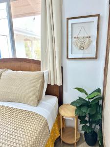 a bedroom with a bed and a plant next to a window at Happy Hill Inn in Kailua-Kona