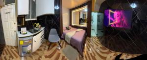 a room with a bed and a sink and a tv at Gold House Premium in Quito