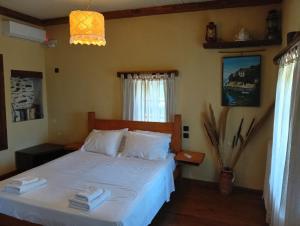 a bedroom with a bed with white sheets at Δυό Πηγές in Mouresi