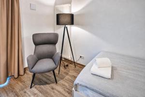 a bedroom with a chair next to a bed at MIILOX Apartments Dresden in Dresden