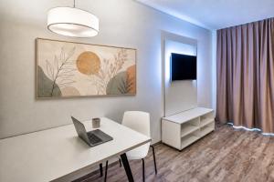 a white room with a desk with a laptop on it at MIILOX Apartments Dresden in Dresden