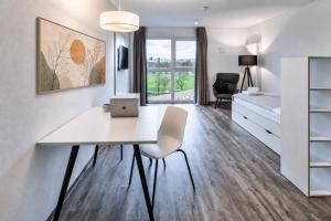 a white room with a desk and a bed at MIILOX Apartments Dresden in Dresden
