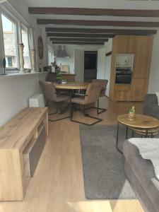 a living room with a table and a kitchen at B&B De Kaagse Boer in Kaag
