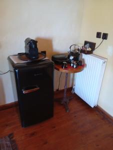 a room with a small table with a small refrigerator and a table with a small at Δυό Πηγές in Mouresi +7 photos