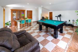 a living room with a couch and a pool table at Casa do Lago guest house in Espinho
