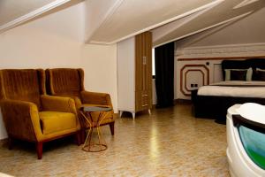 a hotel room with a bed and a chair and a couch at Valero Hôtel in Cotonou +14 photos
