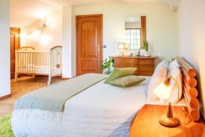 a bedroom with a large bed and a crib at Casa do Lago guest house in Espinho +66 photos