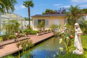 a garden with a pond in front of a house at Casa do Lago guest house in Espinho