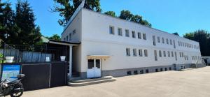 a white building with a motorcycle parked in front of it at Rentumi Hostel Gryfino-Noclegi Turystyczne i Pracownicze in Gryfino