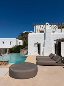 a couch sitting on a patio next to a pool at Topos exclusive Mykonos in Agios Ioannis Mykonos