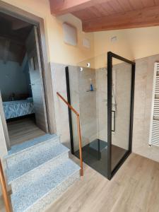 a bathroom with a walk in shower and a staircase at B&B La Plesna in Pella