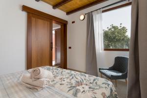 a bedroom with a bed and a chair and a window at Villa Amada in Vega de San Mateo +24 photos
