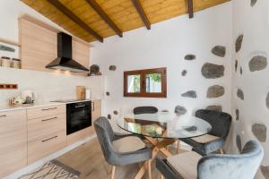 a kitchen with a glass table and chairs at Villa Amada in Vega de San Mateo