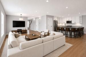 a living room with a white couch and a kitchen at PINE AND TIMBER GETAWAY in Jackson