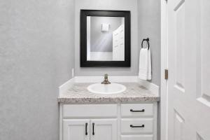 a white bathroom with a sink and a mirror at PINE AND TIMBER GETAWAY in Jackson