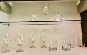 a group of wine glasses sitting on a shelf at Klaipeda City Center Aparment in Klaipėda