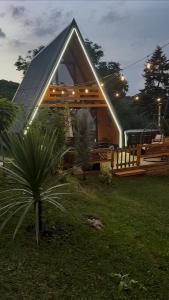 a house with a pointed roof with a palm tree in the yard at Villa Venus in Ferizaj