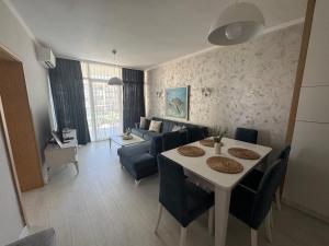 a living room with a table and a couch at Turtle Apartment Sunny Beach in Sunny Beach