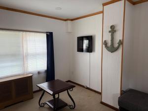 a room with a table and a tv and a window at Floral Canal-Facing Hideaway in Chesapeake City
