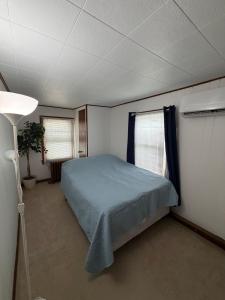 a bedroom with a bed and two windows at Floral Canal-Facing Hideaway in Chesapeake City