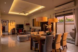 a living room with a dining room table with chairs at Emerald Pool Villa Lush Villa On A Sunny Island in Nai Harn Beach