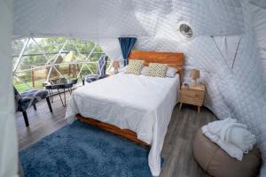 a bedroom with a large bed and a balcony at Altura secreta in Jarabacoa
