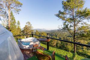 a bath tub sitting on top of a balcony with trees at Altura secreta in Jarabacoa