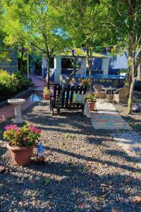a garden with benches and flowers and trees at Villa Naranja AYD in Paredón