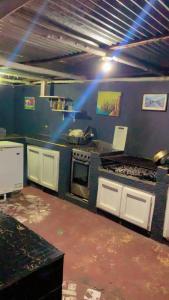 a kitchen with a stove top oven in a room at Villa Naranja AYD in Paredón