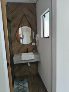 a bathroom with a sink and a mirror at Suíte 15 in Pontal do Paraná