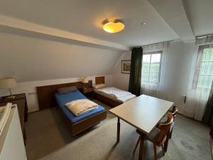a bedroom with a bed and a table and a desk at Monteurwohnung Hohenstadt in Hohenstadt