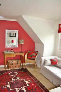 a living room with red walls and a white couch at Hare Lodge B&B in Tisbury