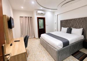 a hotel room with a bed and a desk at Valero Hôtel in Cotonou