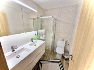 a white bathroom with a sink and a toilet at Estúdio com cozinha e casa de banho! in Bragança +24 photos
